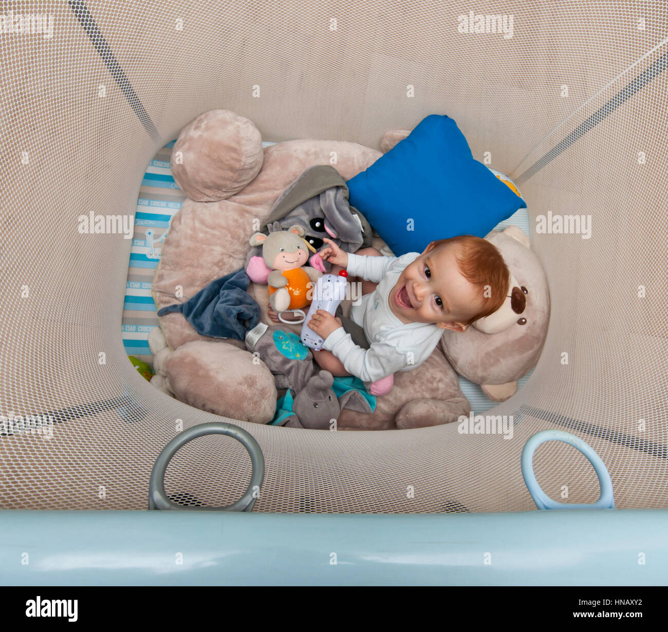 Capelli rossi kid giocare in un box per bambini Foto Stock