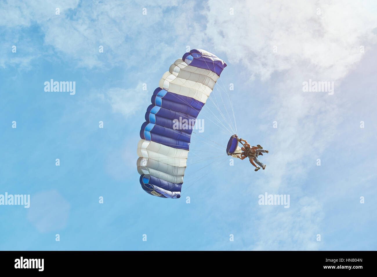 Uomo con blue isolato di parapendio su sky Foto Stock