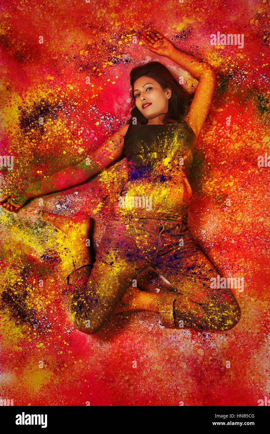 Elevato angolo di visione di un adolescente indiano ragazza distesa e coperto di polvere colorata durante Holi festival a colori Foto Stock