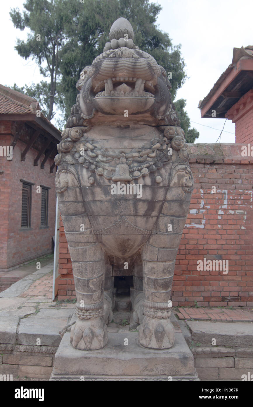 Stilizzazione di una pietra scolpita lion sta di guardia al di fuori di un tempio a Bhaktapur località di Kathmandu, Nepal Foto Stock