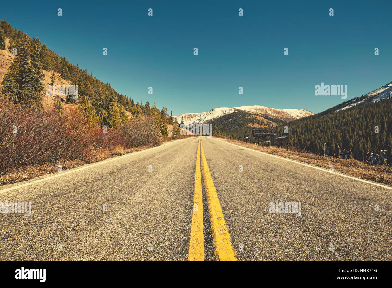 Retrò dai toni di colore scenic mountain road, concetto di viaggio foto, Colorado, Stati Uniti d'America. Foto Stock