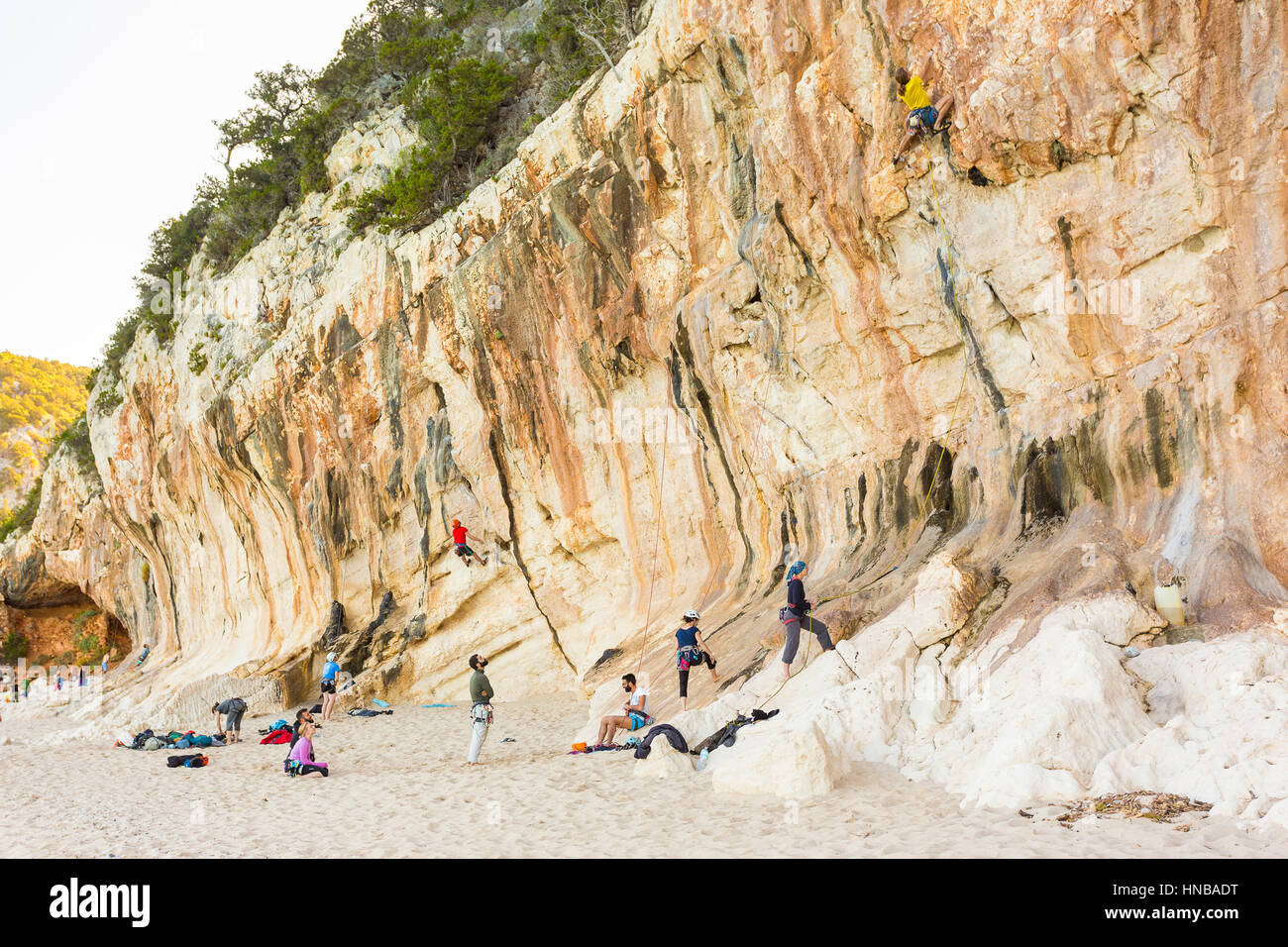 Alcuni arrampicatori salire sulla scogliera della cala Luna, Golfo di Orosei, Nuoro Sardegna, Italia, uno dei punti migliori per arrampicate Foto Stock