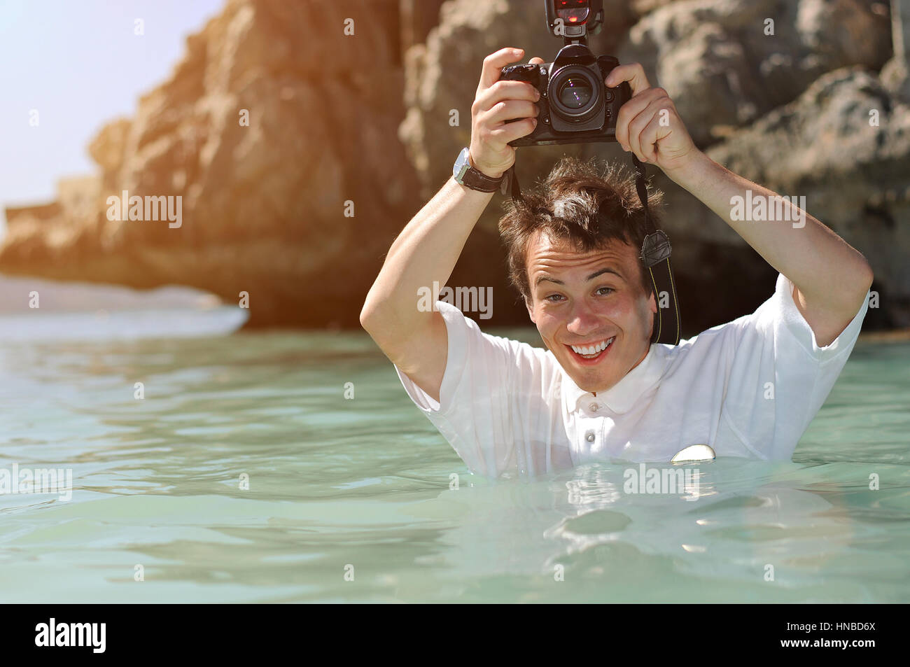 Fotografo tenere la fotocamera nel mare dei Caraibi a mezzo busto Foto Stock
