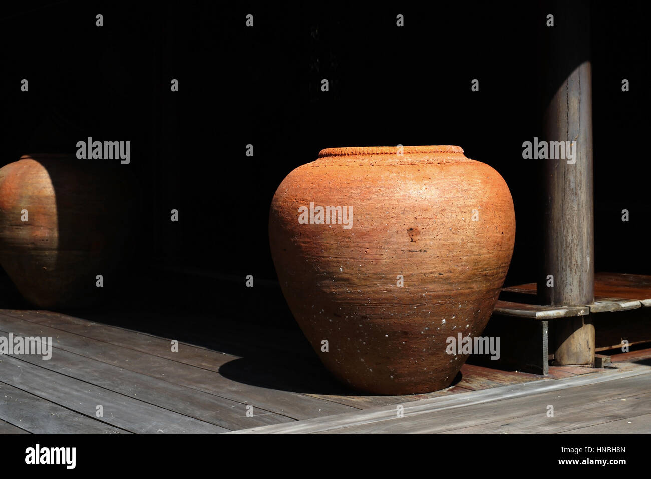 Età di terracotta jar acqua in thai house Foto Stock