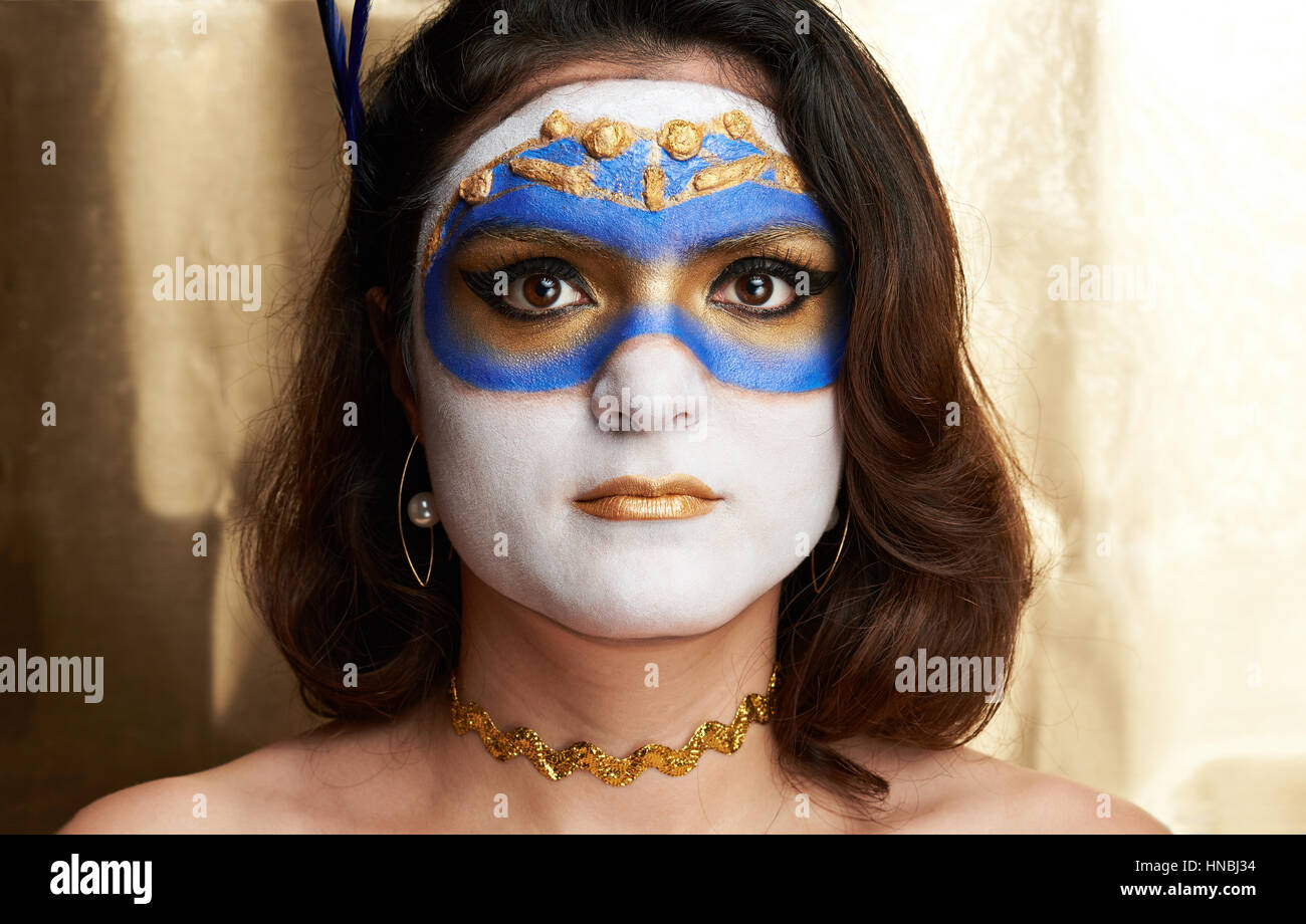 Dipinto di golden maschera sul volto delle donne su fondo oro Foto Stock