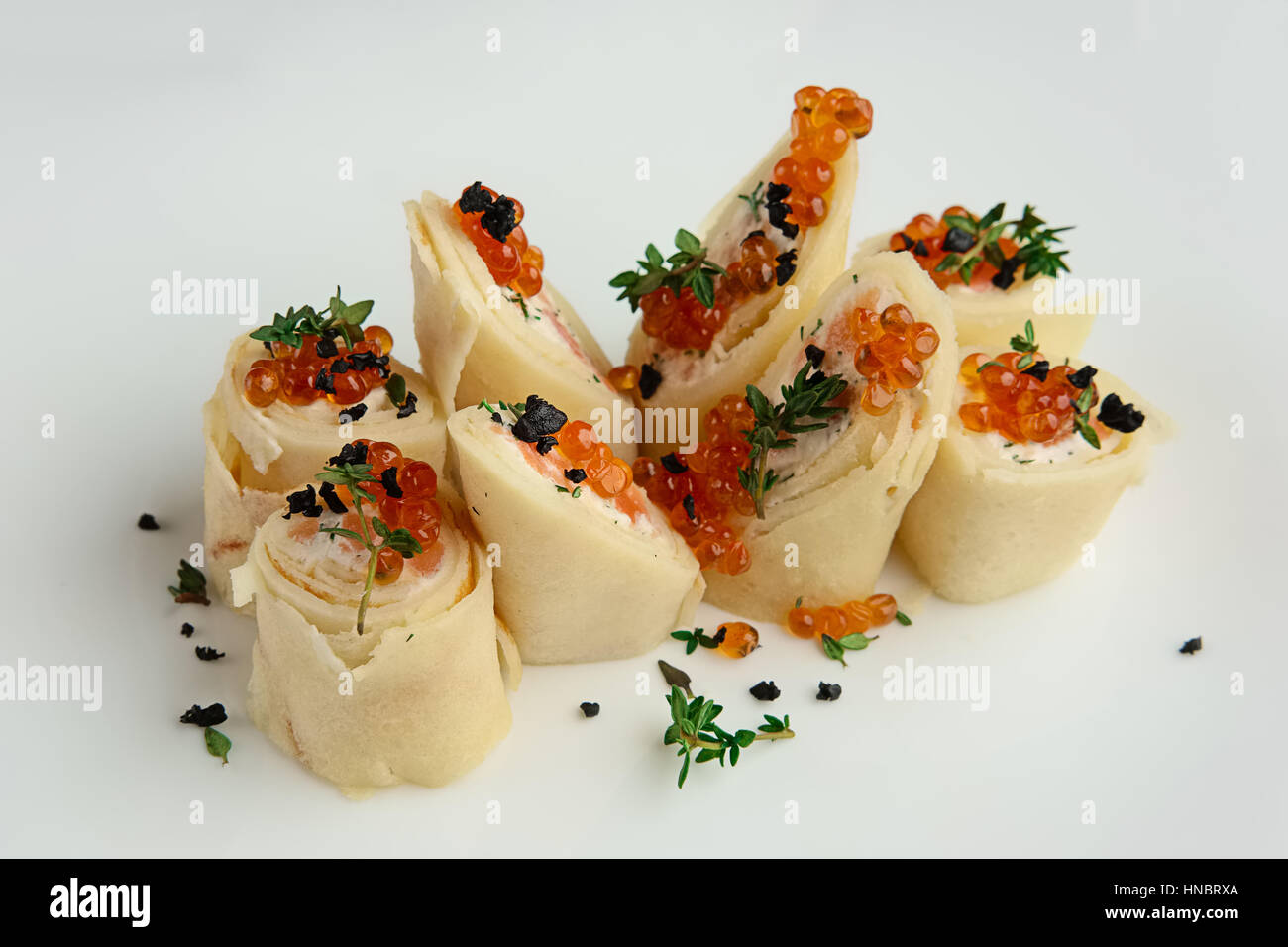 Vista ravvicinata di frittelle con salmone e caviale sulla grande piastra bianca Foto Stock