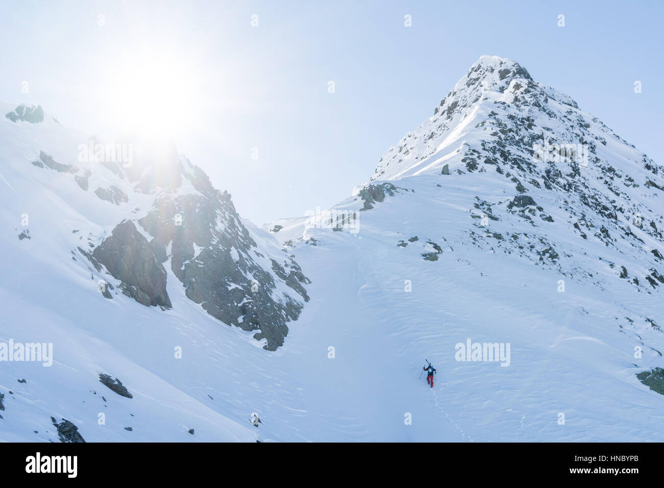 Sciatore salendo su un pendio ripido, Tirolo, Austria Foto Stock
