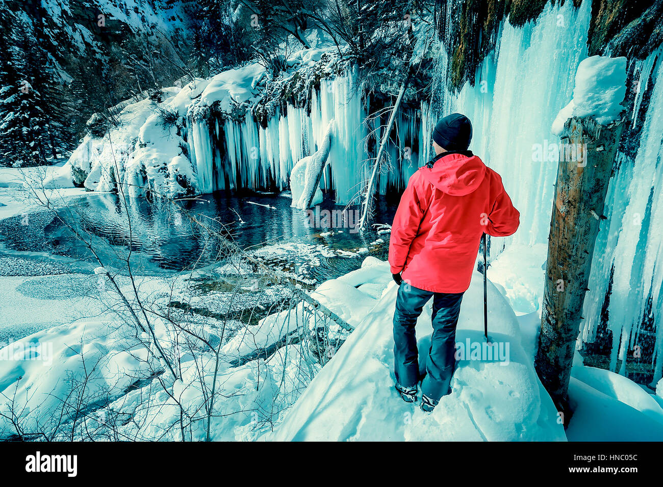 Uomo in piedi di fronte alla cascata ghiacciata, Hanging Lake, Colorado, Stati Uniti Foto Stock