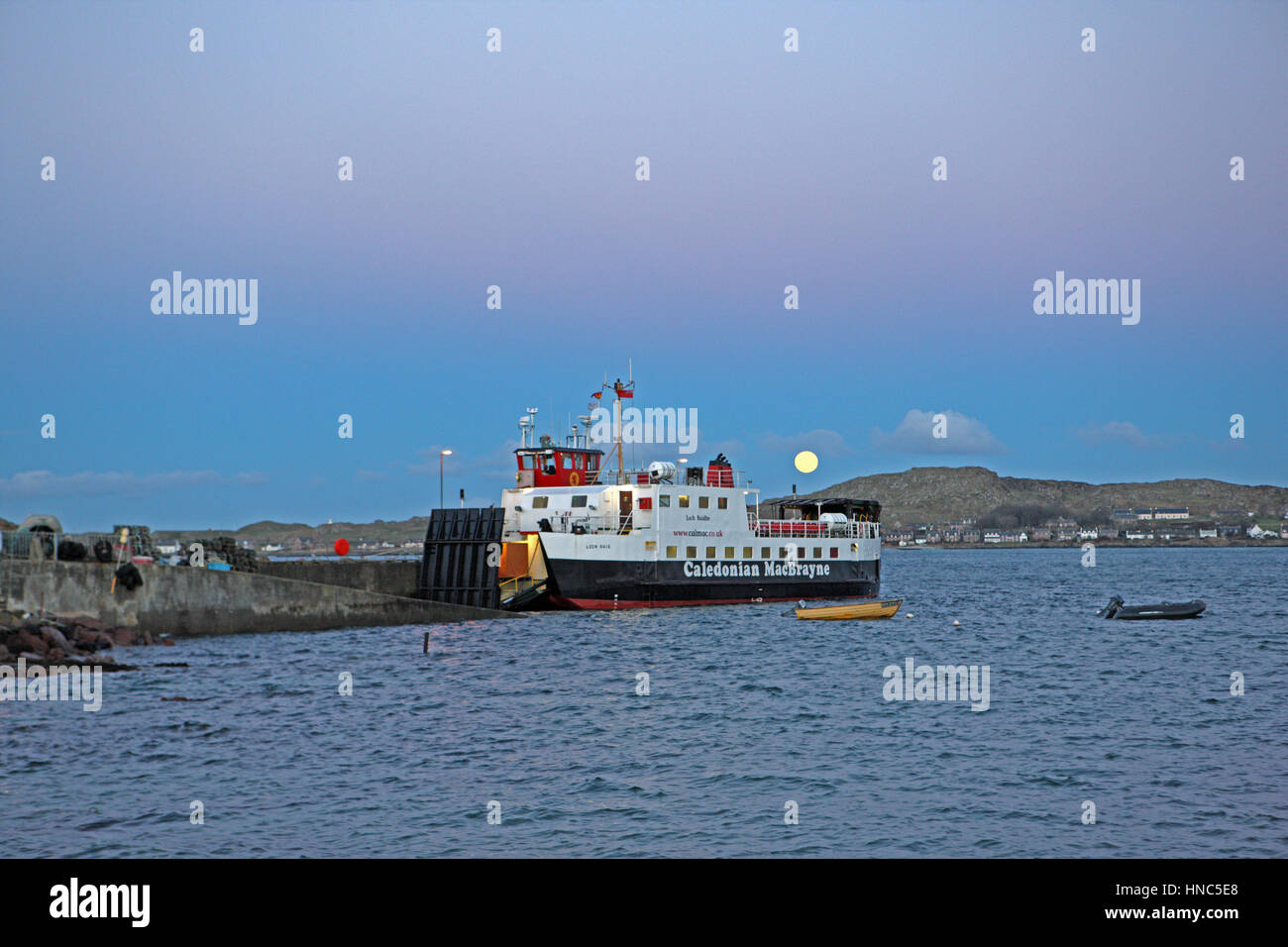 Iona, Scotland, Regno Unito. Xi Febbraio 2017. Febbraio Luna Piena noto come "ora luna" scendendo dietro l'isola di Iona nelle Ebridi Interne della Scozia. Il Loch Buie, Calmac ferry a Fionnphort sull'Isle of Mull è in primo piano. Credito: PictureScotland/Alamy Live News Foto Stock