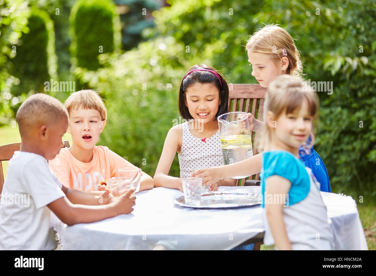 Bambini festa di compleanno con i bambini a bere acqua in estate Foto Stock