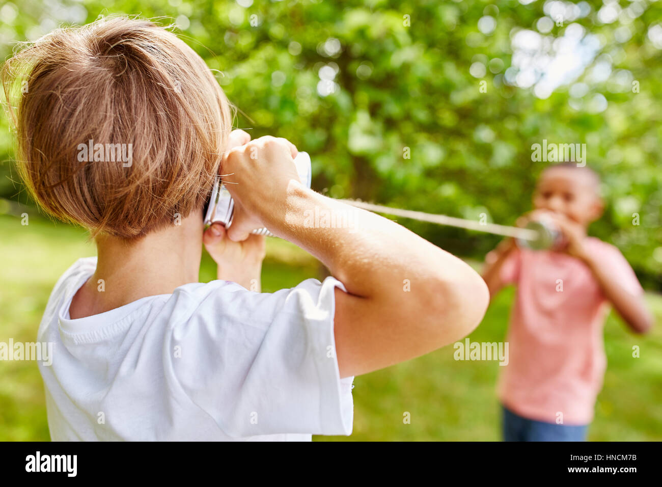Ragazzi che giocano a stagno possono telefonare in estate nel parco Foto Stock