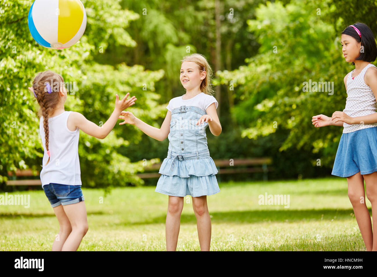 Interracial gruppo di bambini giocare a palla in estate Foto Stock