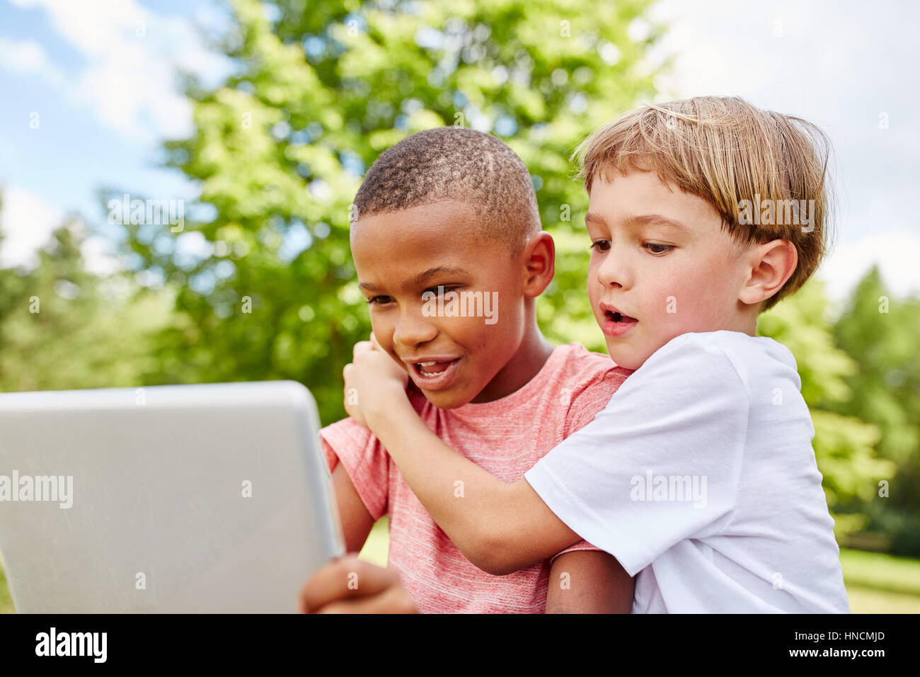 Due ragazzo giocando con il laptop e l'utilizzo di internet per la comunicazione Foto Stock