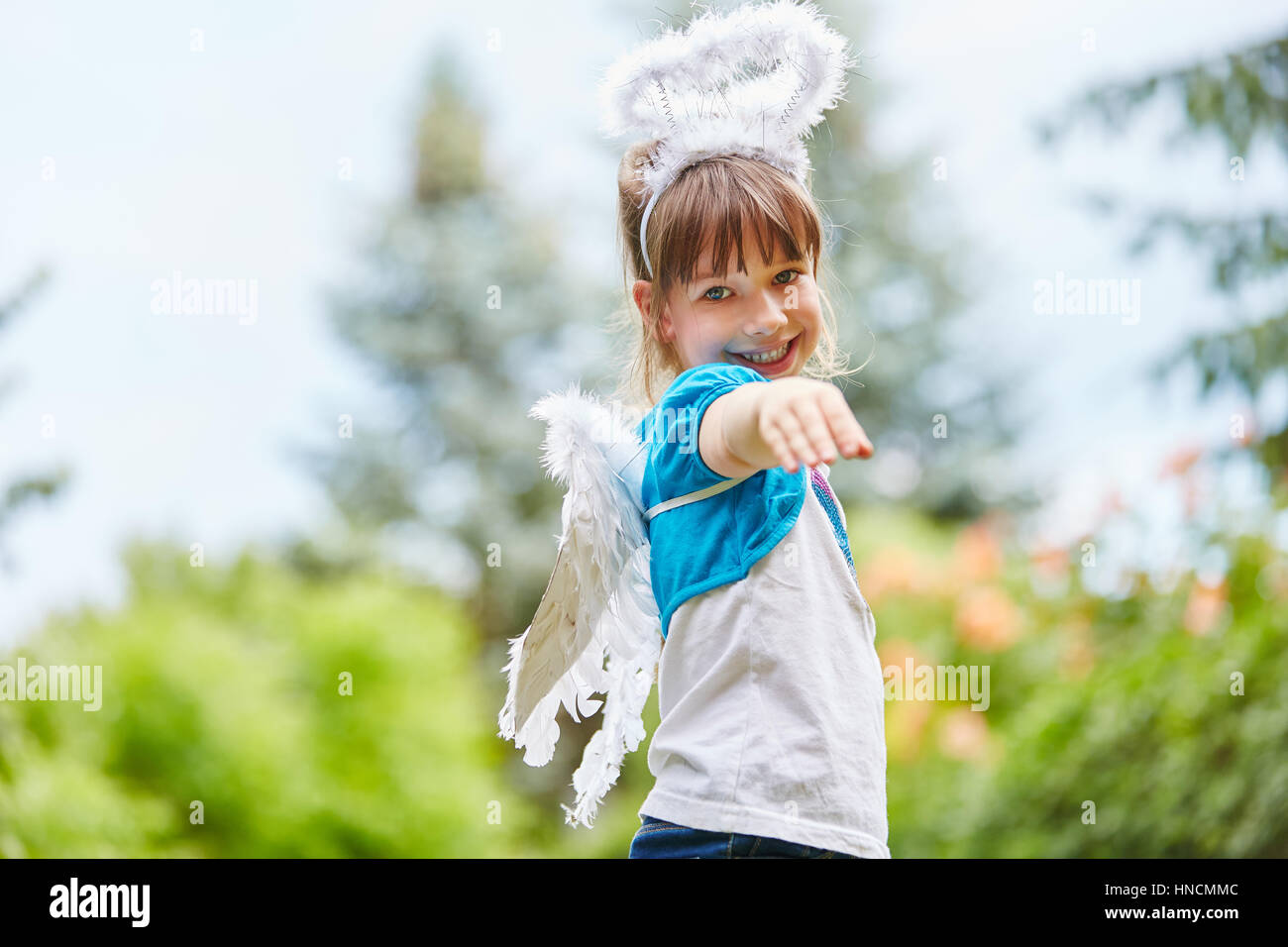 Ragazza con ali e Angelo costume ha divertimento in giardino Foto Stock