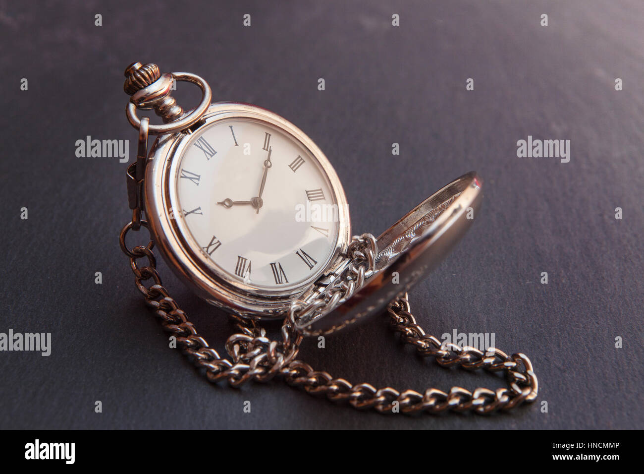 Vecchio argento vintage orologio da tasca sulla pietra grigia superficie, closeup con estrema profondità di campo Foto Stock
