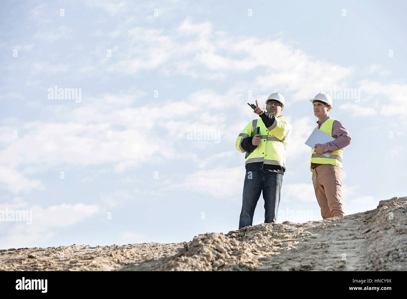 Basso angolo di visione dei supervisori discute al sito in costruzione contro sky Foto Stock