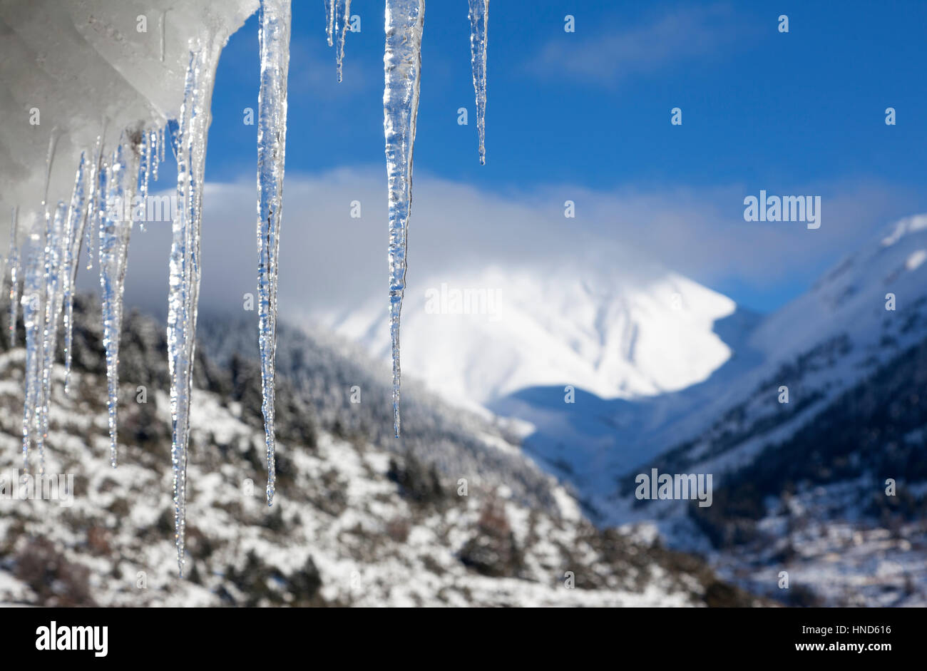 Temporal stalattiti pendenti da un tetto di tegole, in un giorno di neve a destra nel mezzo dell'inverno, in zone di montagna in Grecia. Foto Stock