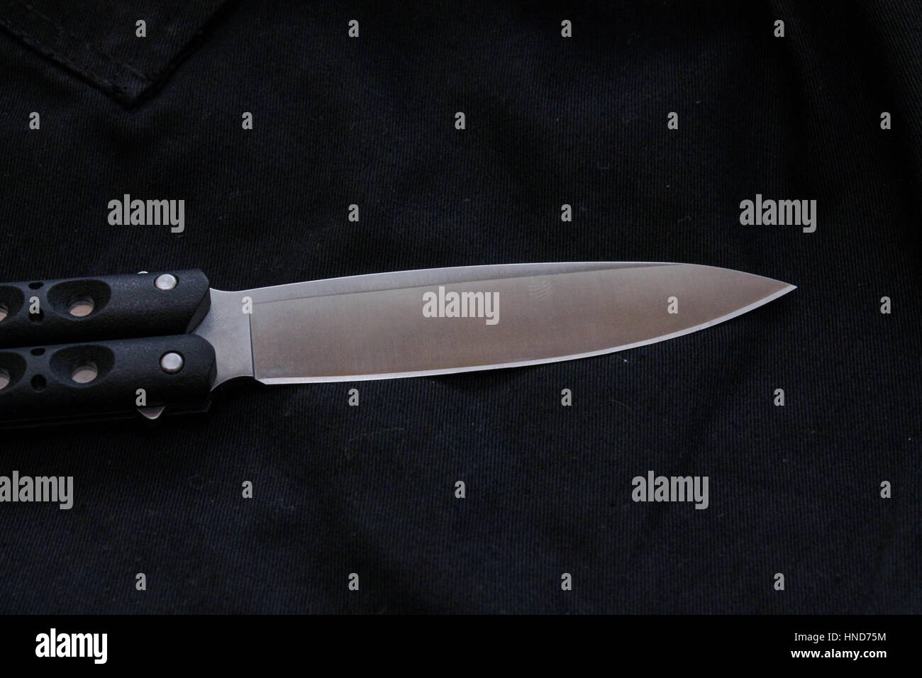 Lama di coltello su sfondo nero. Maniglia nera e lama bianca. Foto Stock