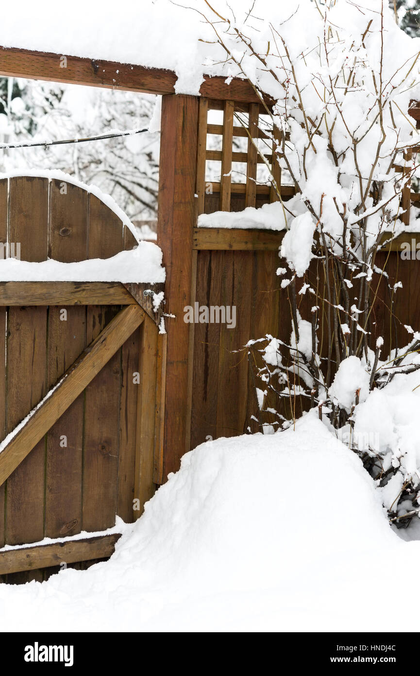 La neve su un legno cancello del giardino Foto Stock