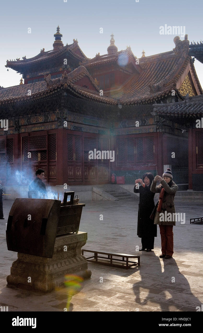 Pregate, pregando, offrendo, credente alla Yong he Gong tempio lama pregando e la combustione di bastoncini di incenso,Beijing, Cina Foto Stock