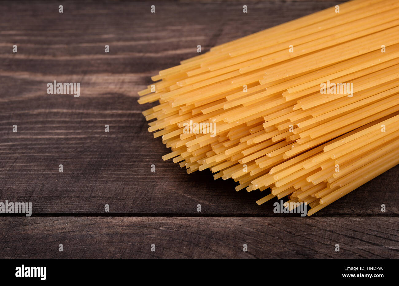 Spaghetti secchi su legno scuro dello sfondo Foto Stock