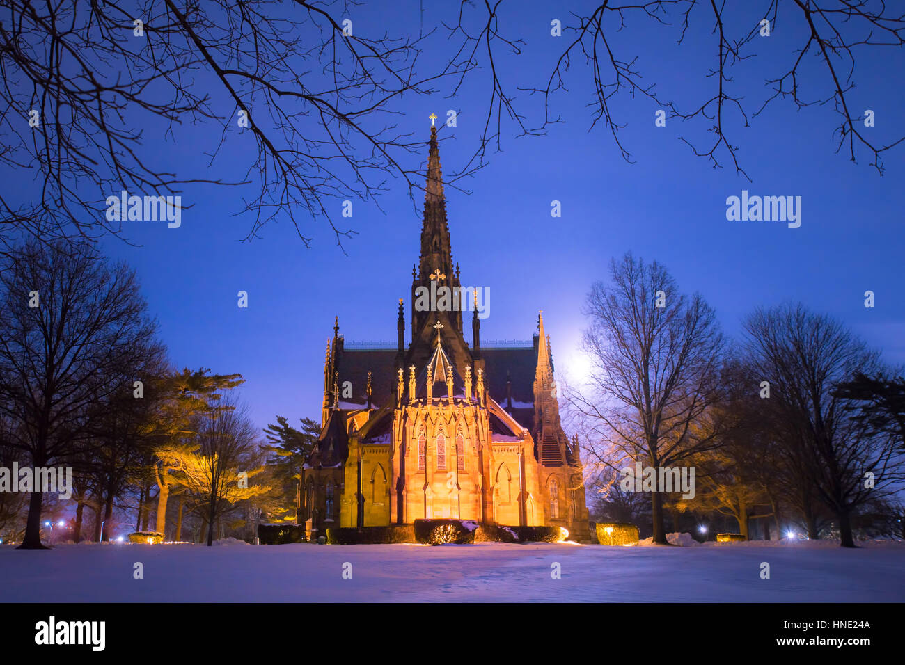 Bella cattedrale chiesa visibile su un inverno nevoso notte con luna incandescente in background Foto Stock