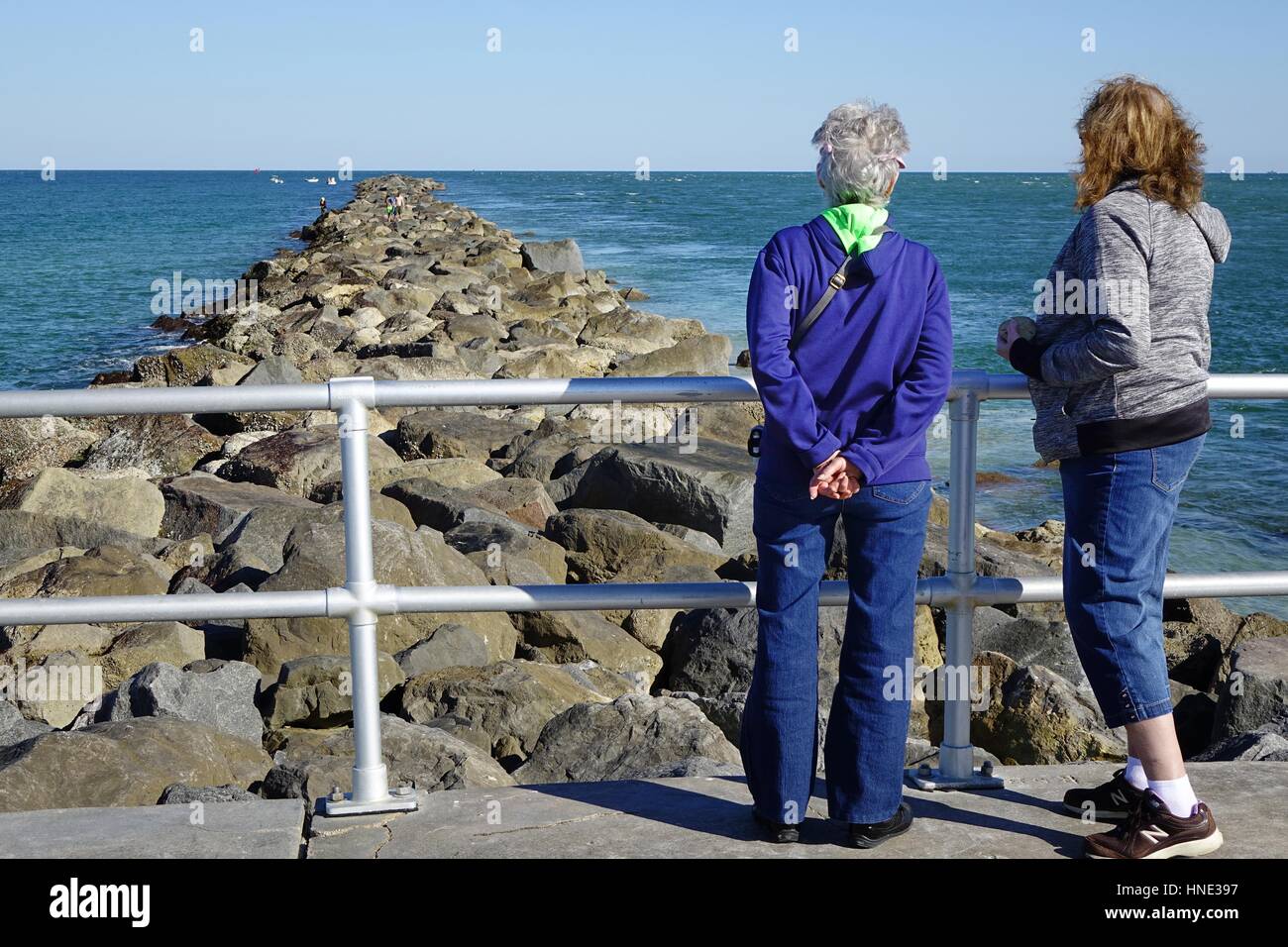 Due donne guardando sopra la roccia molo al Lighthouse Point Park, Ponce Inlet, Florida Foto Stock