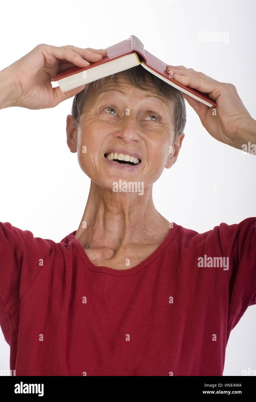 Modello di rilascio, Frau, 60+, mit Buch am Kopf - donna, 60 + , con libro sulla testa Foto Stock