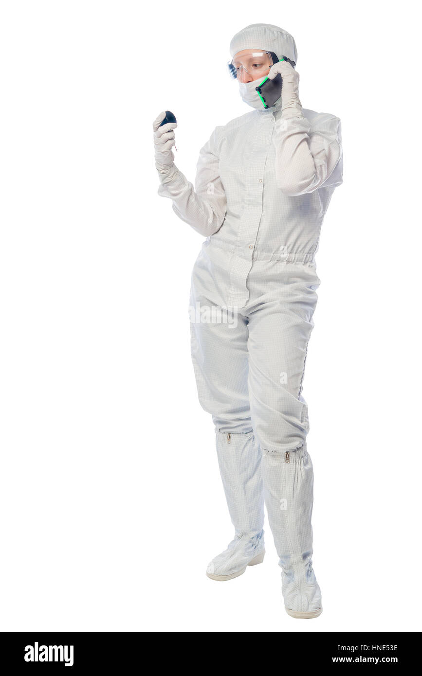 Il farmacista ricercatore con un telefono e uno strumento per misurare la radiazione su di uno sfondo bianco Foto Stock