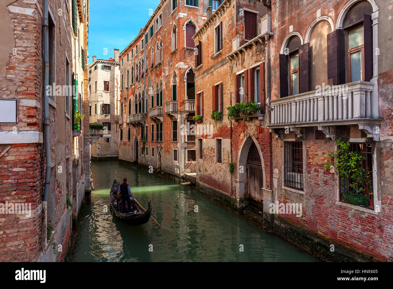 Gondola sul Canal stretta tra le vecchie case in mattoni a Venezia, Italia. Foto Stock