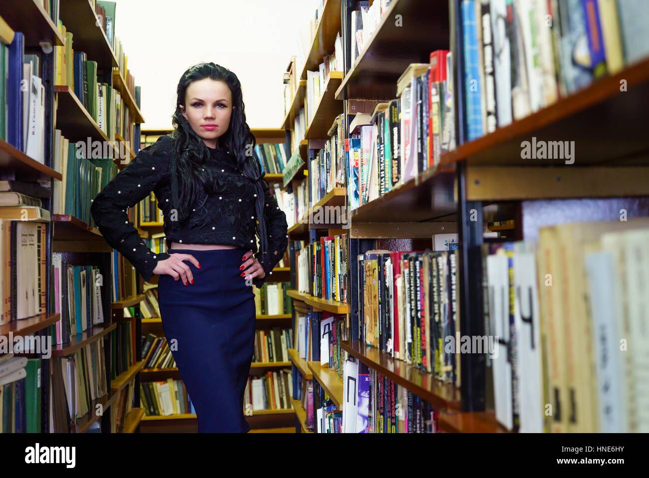 Modello donna in posa per la telecamera in libreria Foto Stock