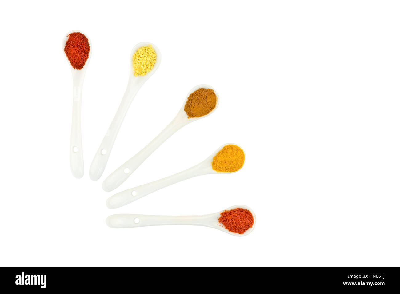 Assortimento di spezie condimento su porcellana cucchiai isolati su sfondo bianco Foto Stock
