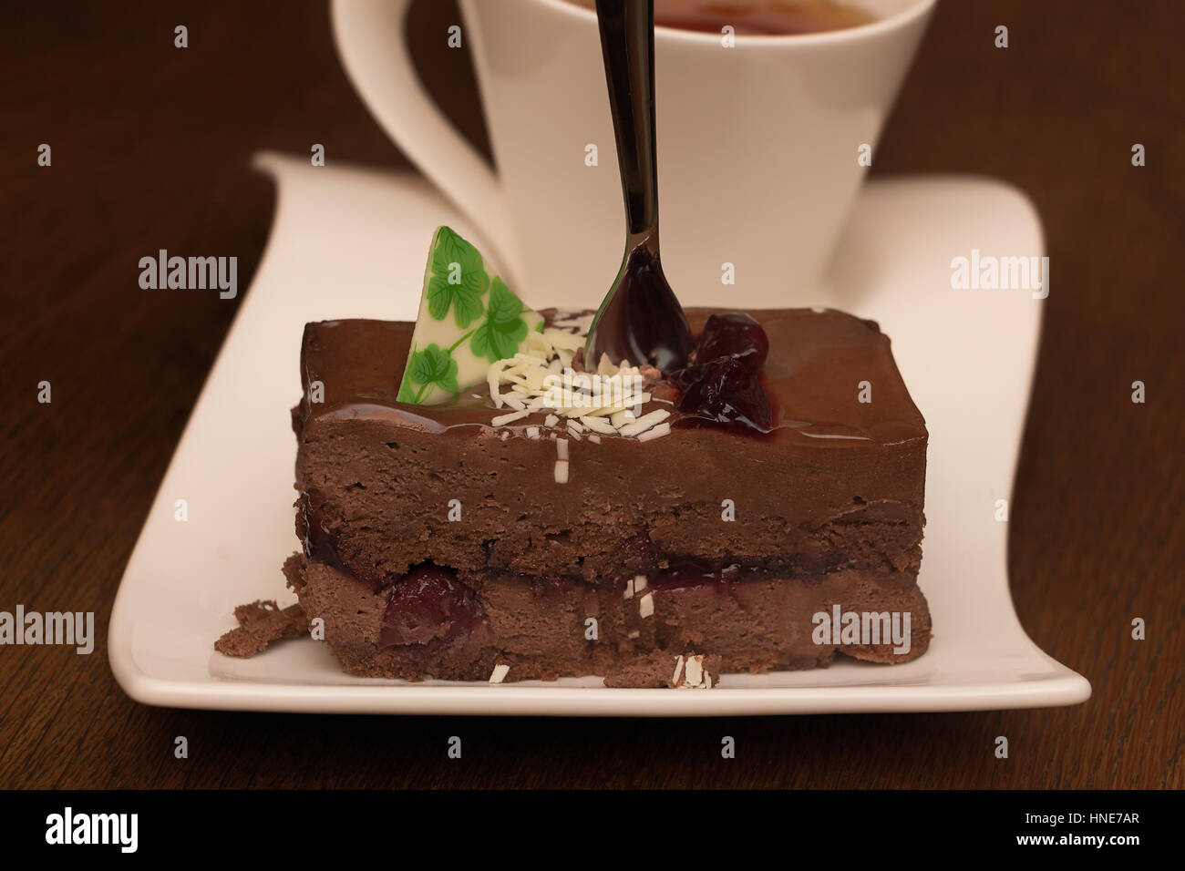Torta al cioccolato o dolce con il tè del pomeriggio su rustico tavolo marrone. Foto Stock