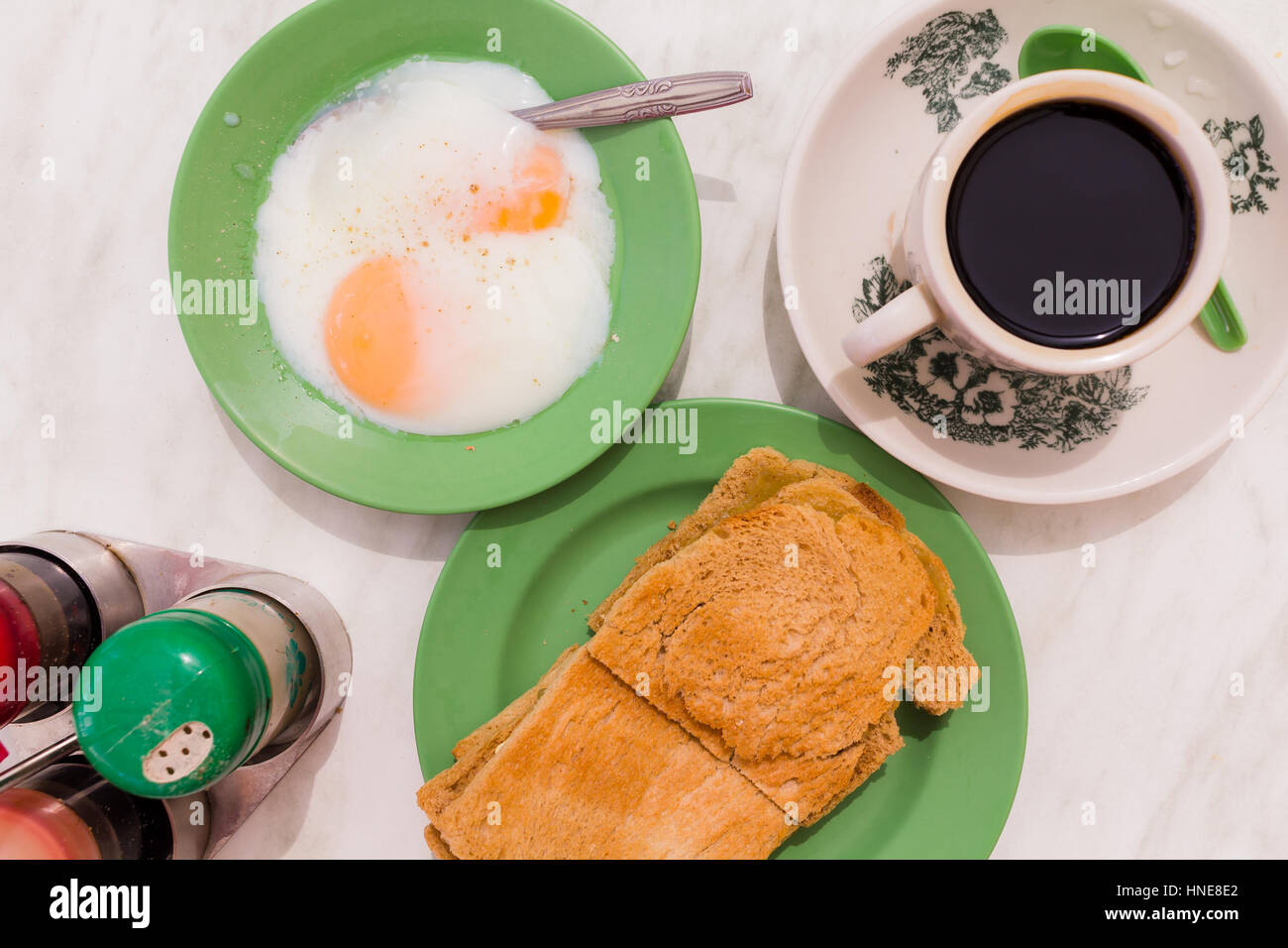 Tradizionale Cinese orientale caffè nella tazza vintage originale e pane tostato con kaya un inceppamento del locale a base di uova, lo zucchero e il latte di cocco Foto Stock