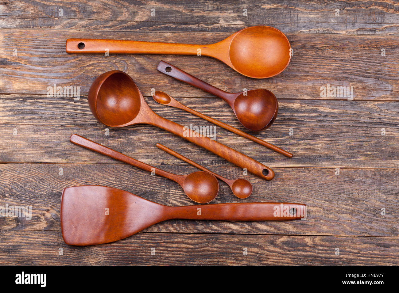 Un assortimento di articoli per la tavola di legno di mestoli e cucchiai sul tavolo di legno Foto Stock