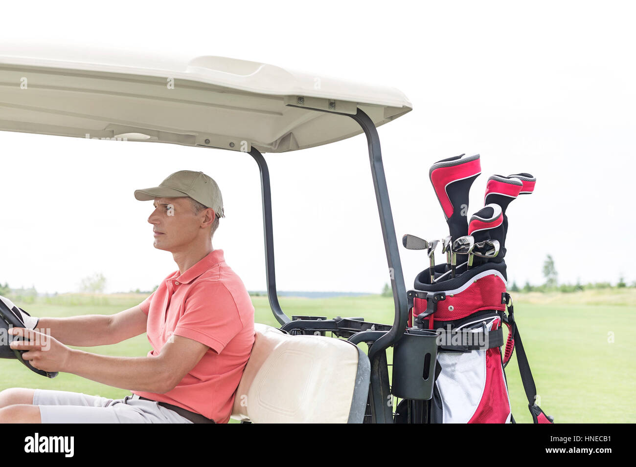 Uomo di mezza età la guida carrello da golf in corso Foto Stock