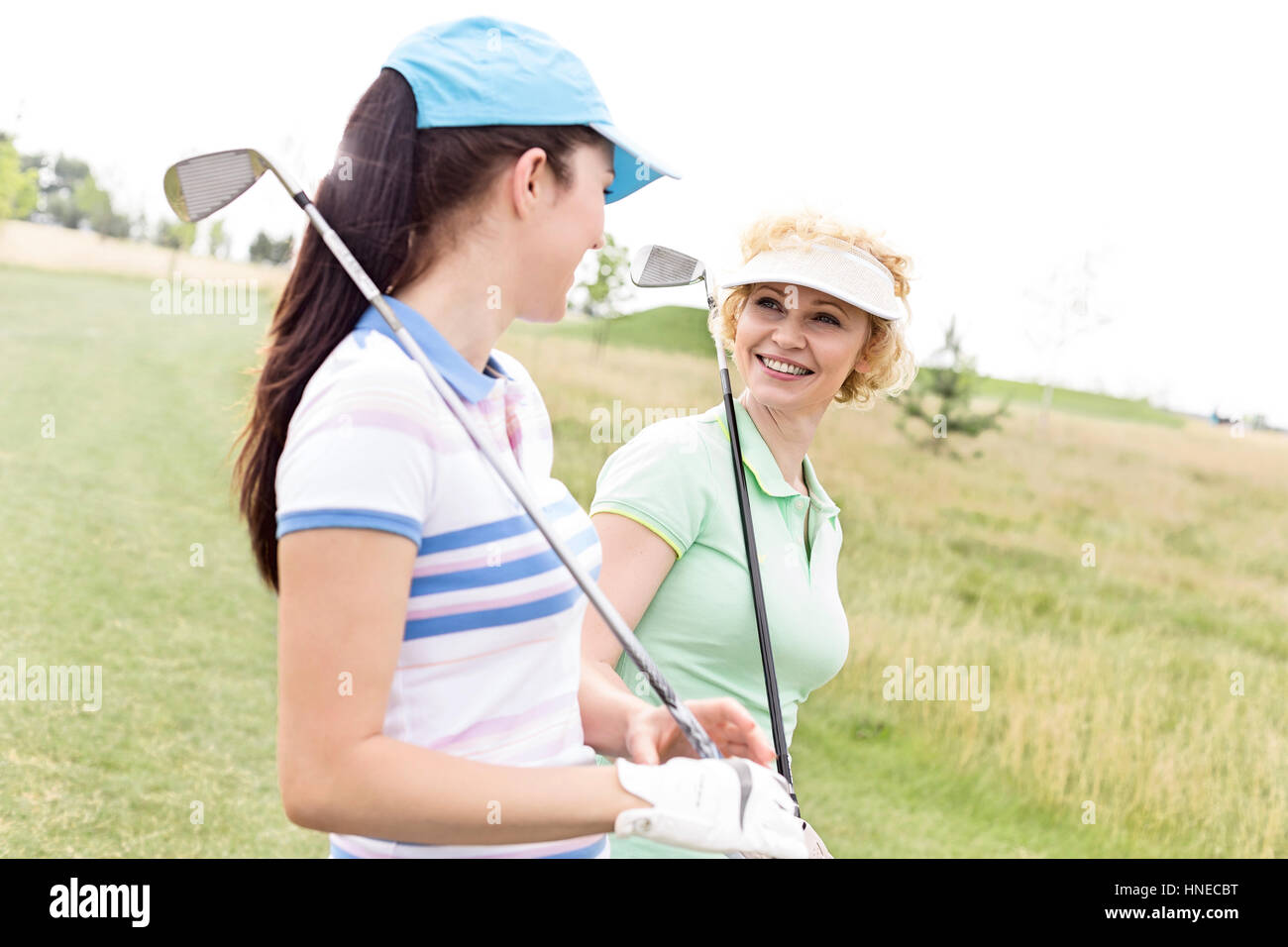 Felice golfisti femmina parlando a campo da golf Foto Stock