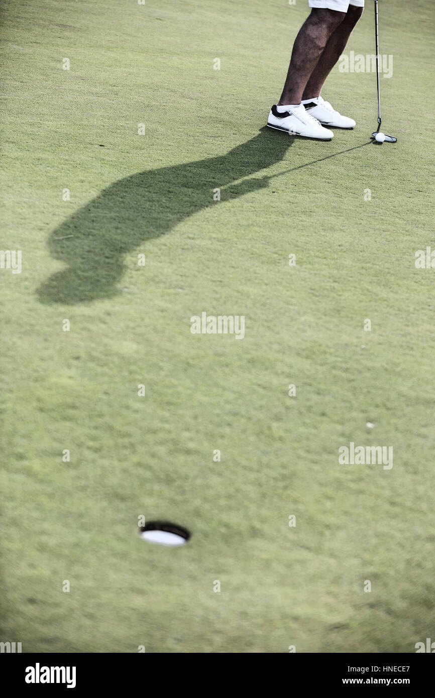 Sezione bassa di uomo di mezza età giocare a golf in corso Foto Stock
