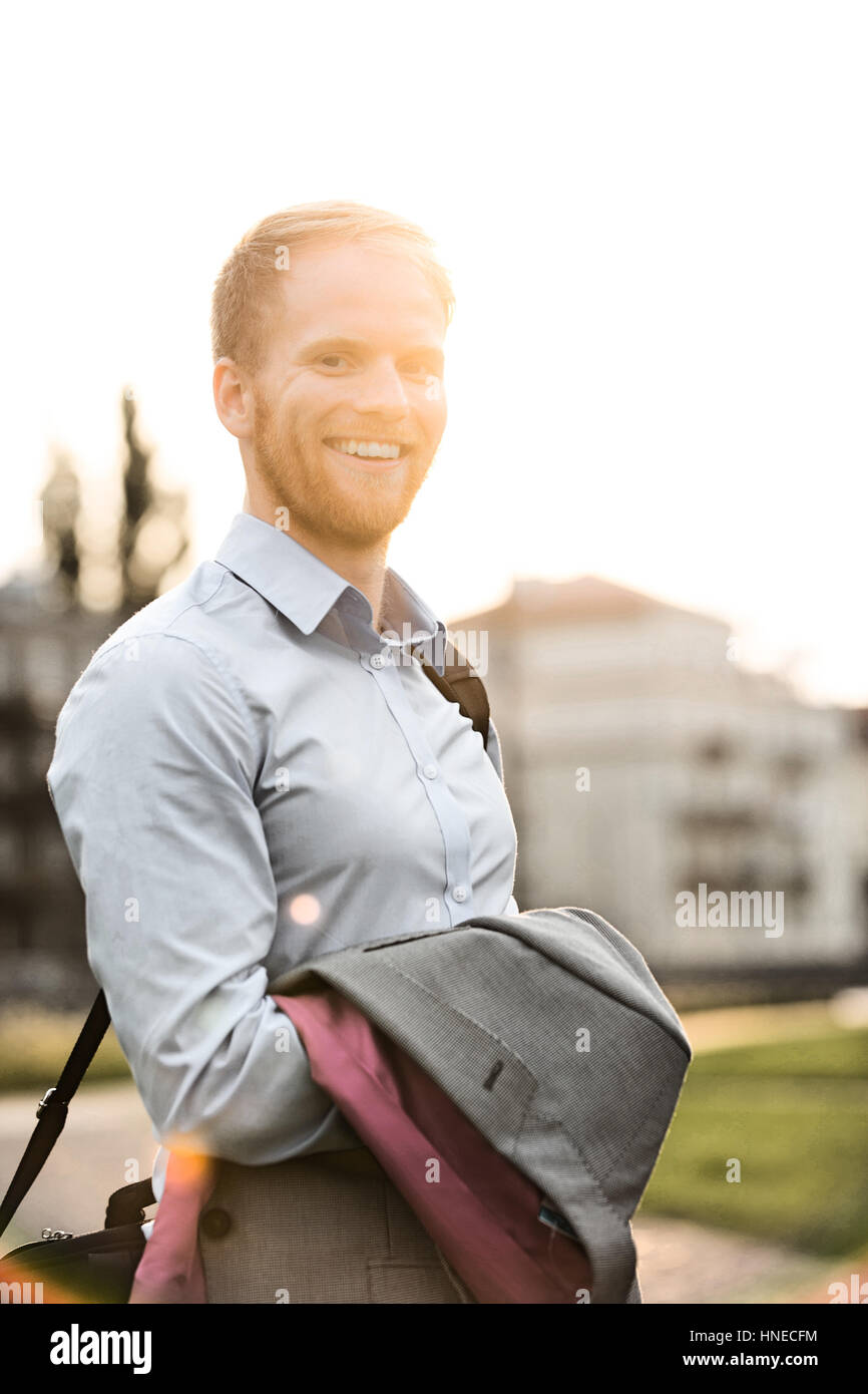 Ritratto di happy businessman in piedi all'aperto sulla giornata di sole Foto Stock