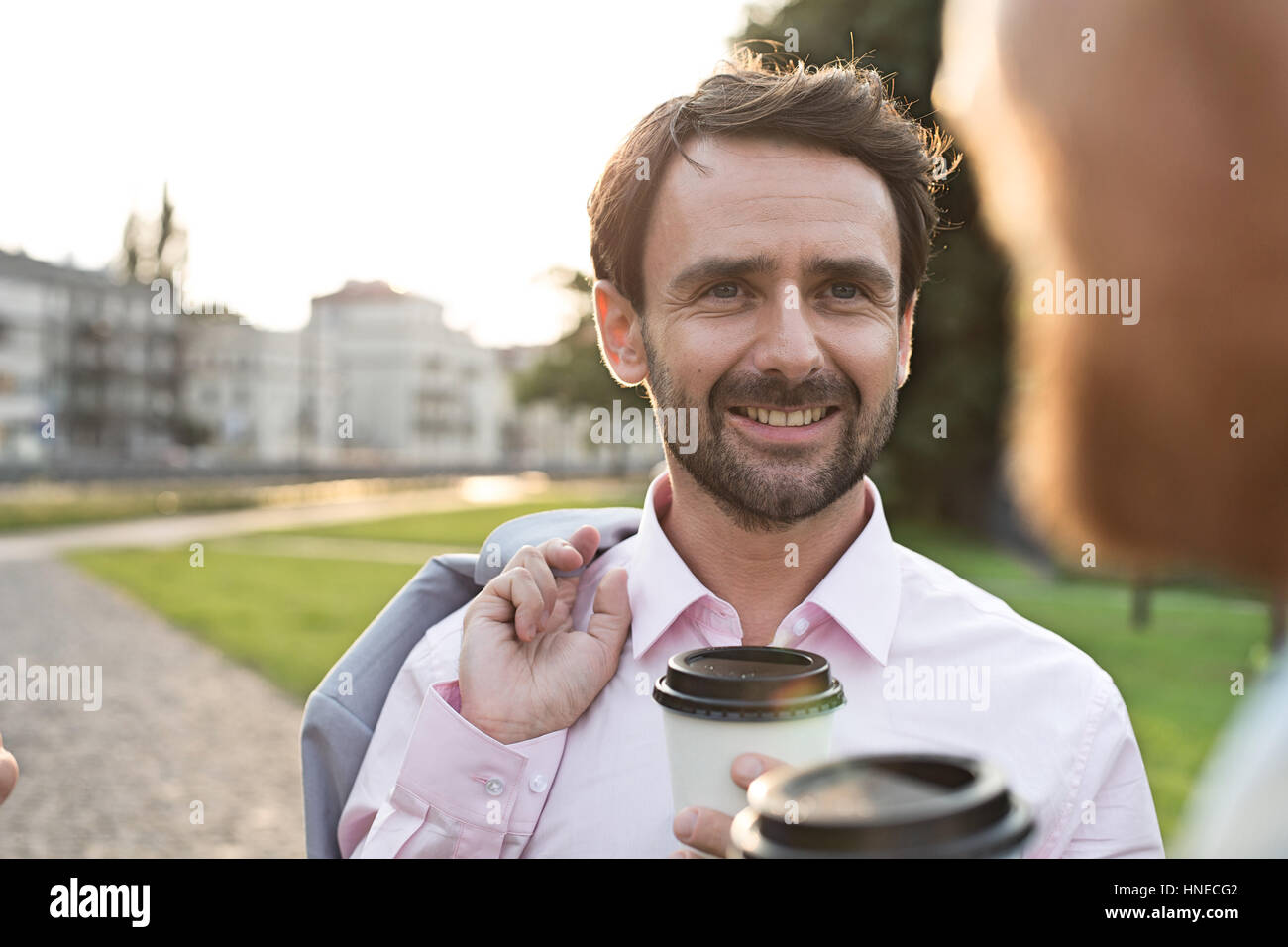 Happy businessman con un collega sul parco sulla giornata di sole Foto Stock