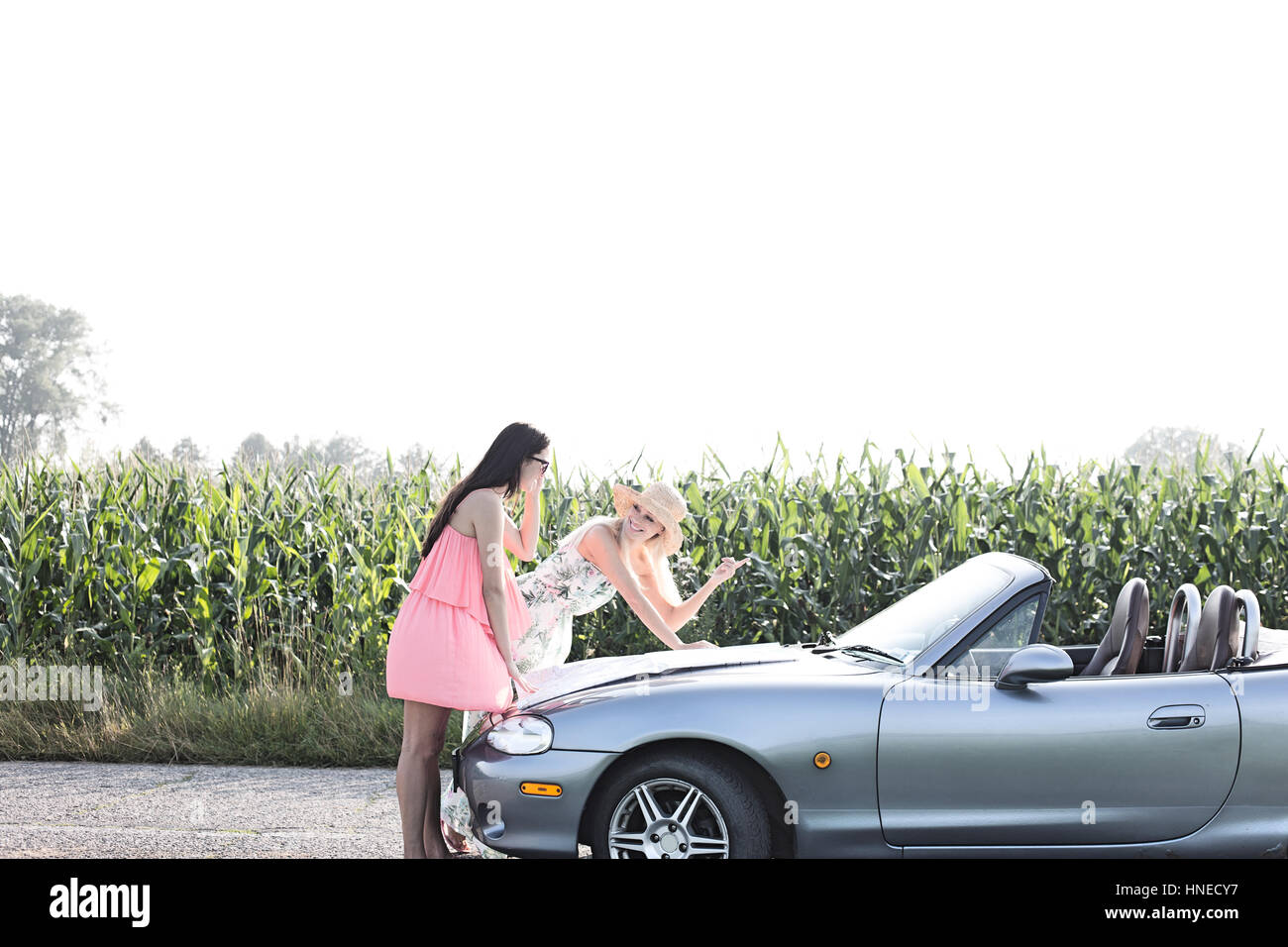 Le donne di lettura sulla mappa convertibili in campagna Foto Stock