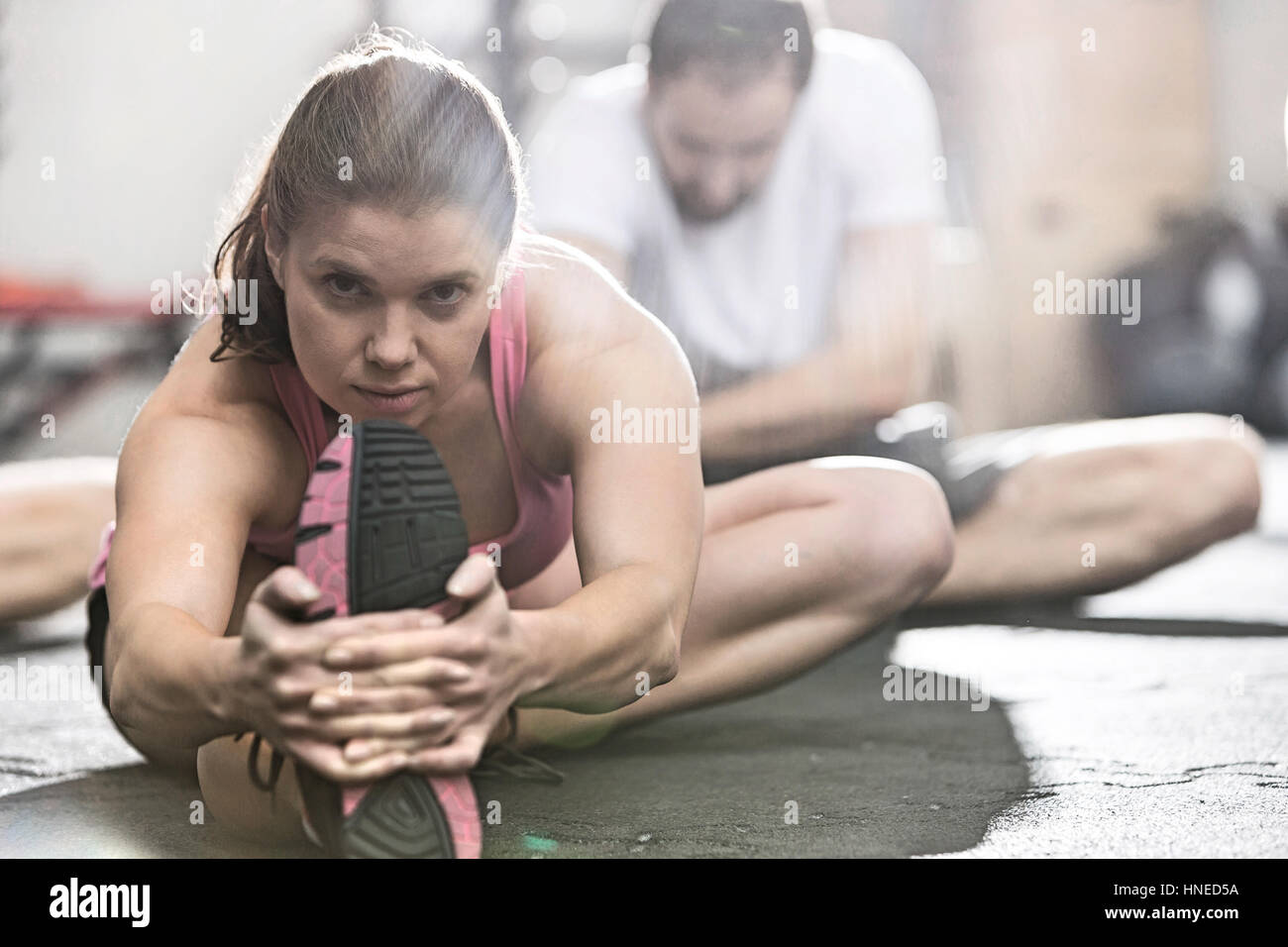 Ritratto di donna fiducioso facendo stretching esercizio in palestra crossfit Foto Stock