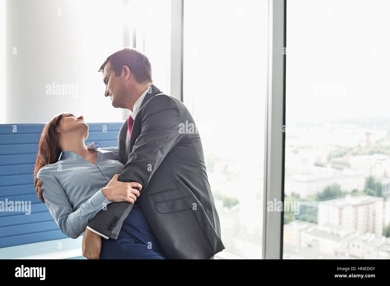 Business amorevole coppia danzante in office Foto Stock