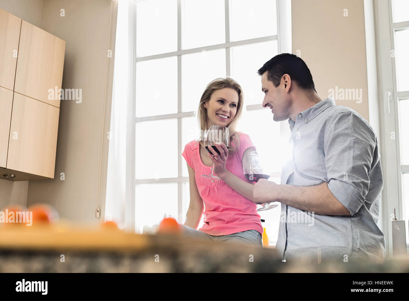 Coppia felice di bere il vino rosso in cucina Foto Stock