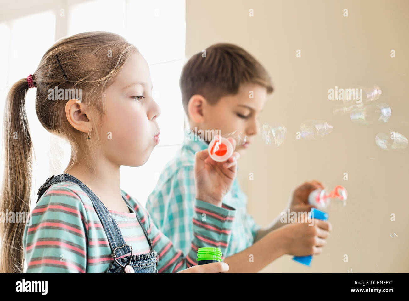 Fratello e Sorella gioca con bacchette di bolle a casa Foto Stock