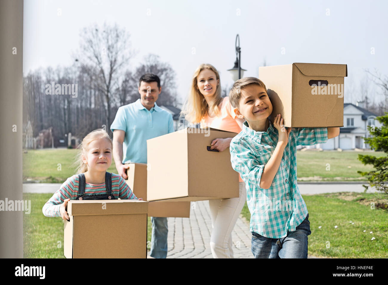 Famiglia con scatole di cartone in movimento nella nuova casa Foto Stock