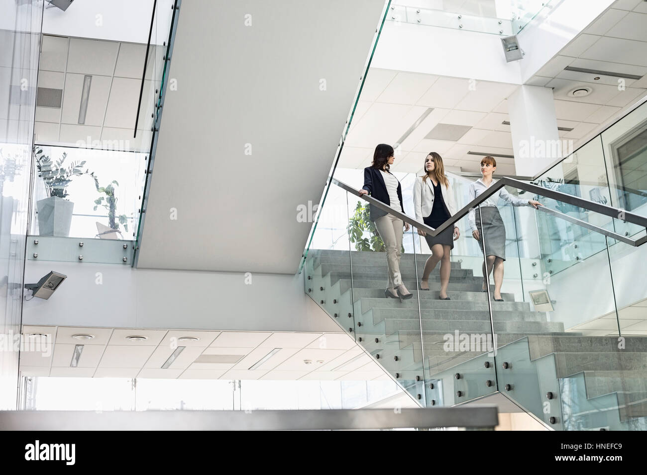 Imprenditrici a conversare mentre si sta spostando verso il basso le fasi in office Foto Stock