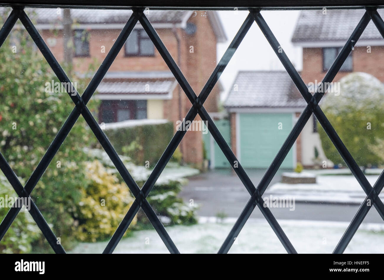 Guardando fuori attraverso un vetro piombato finestra case di fronte, sull'altro lato della strada. Foto Stock