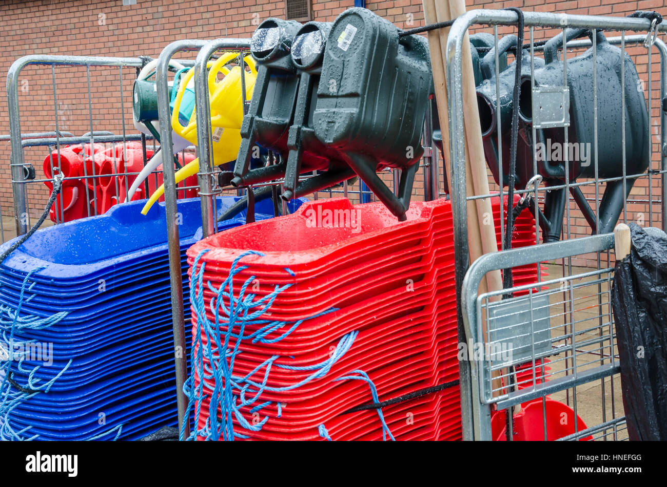 Un display di slitte in plastica e innaffiatoi al di fuori di un hardware shop. Foto Stock