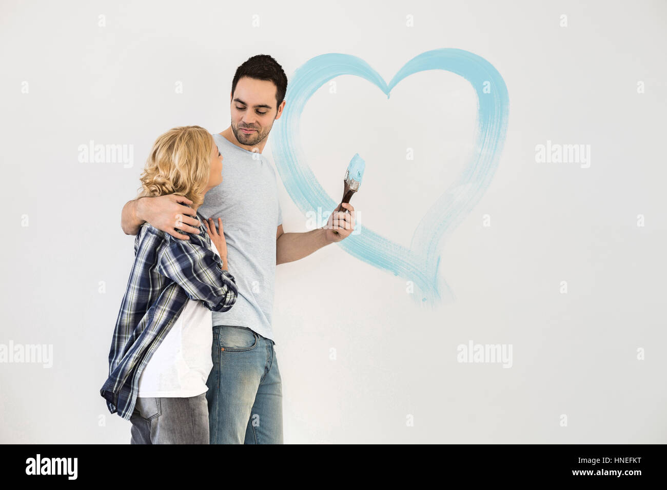 Amare mid-adulto giovane con cuore dipinta sulla parete Foto Stock